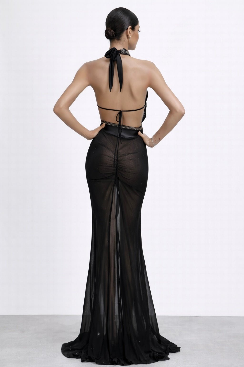 Back view highlighting open halter ties, ruched mesh, and sweep train.